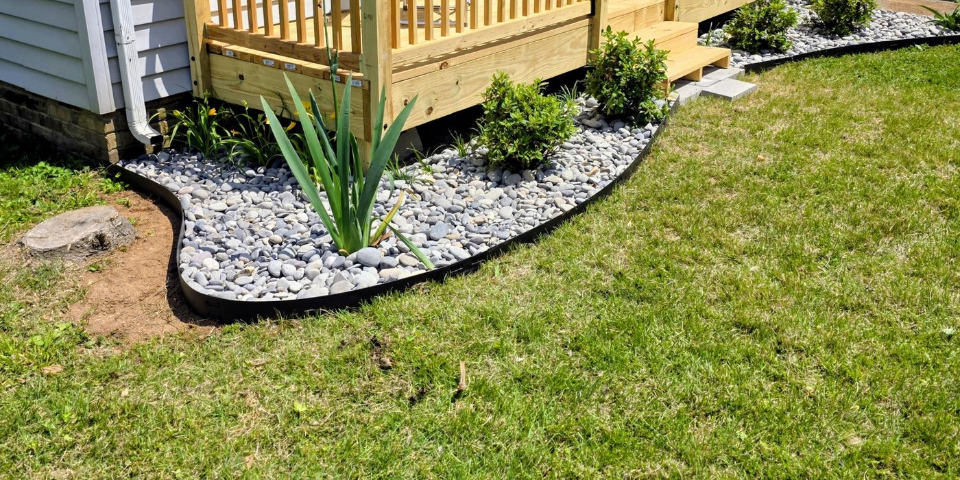 River-rock bed with fresh plantings curving around a new deck